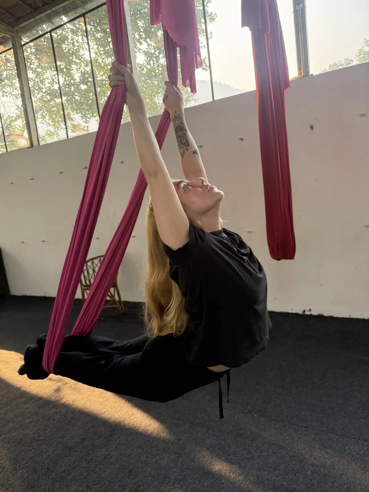 Student in a supported aerial yoga backbend