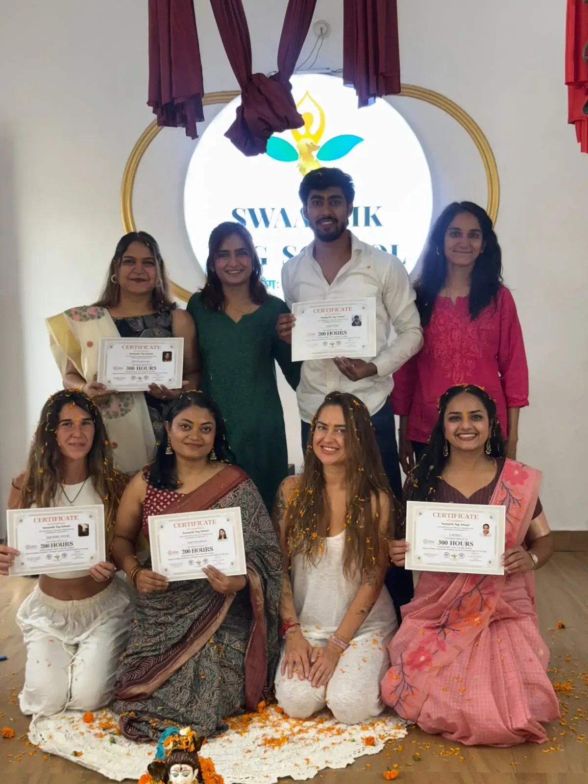 Graduates holding their Yoga Alliance certificates at Swaastik Yog School
