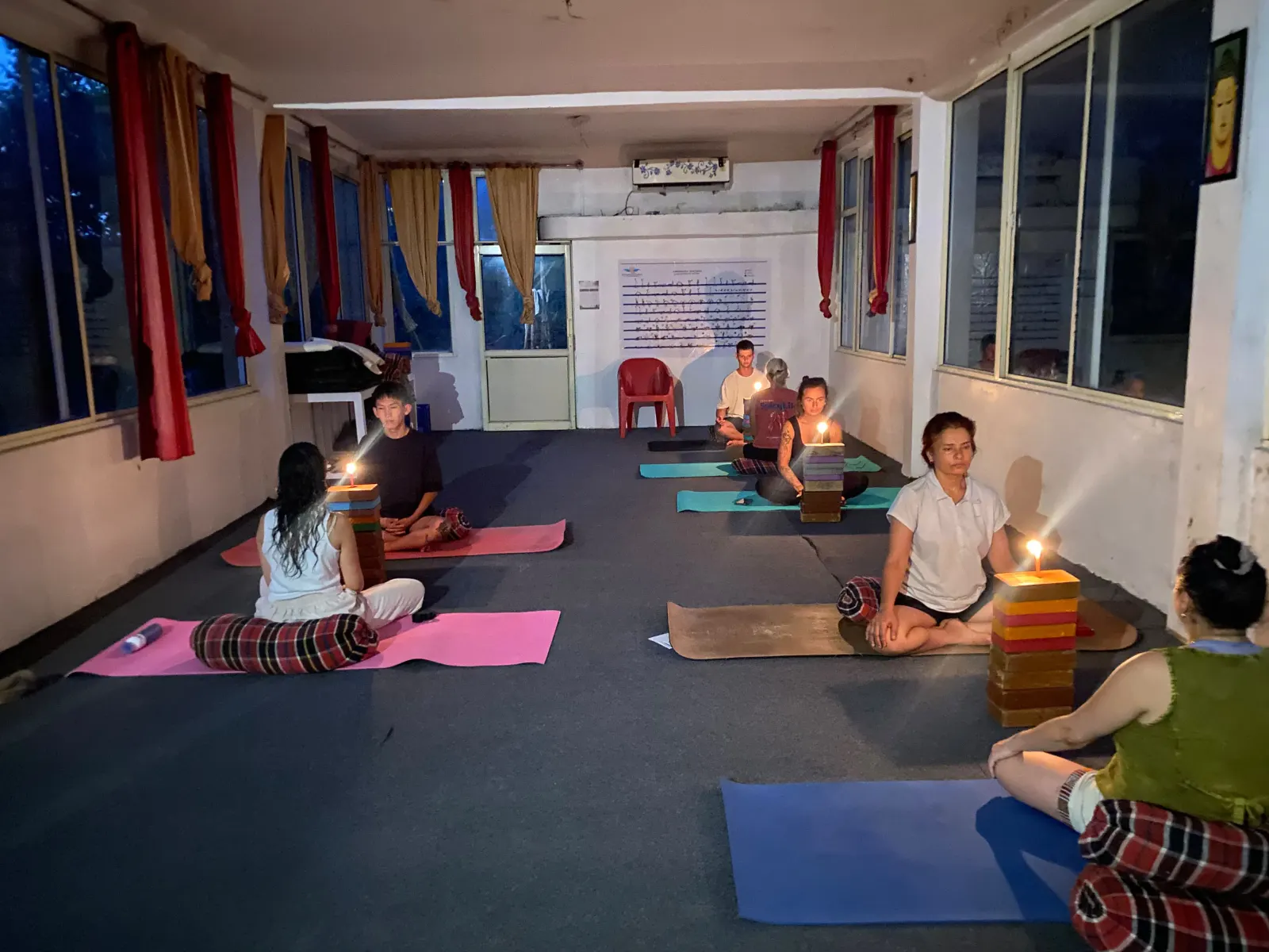 Candlelit meditation practice in the Swaastik Yog School yoga hall in Tapovan, Rishikesh