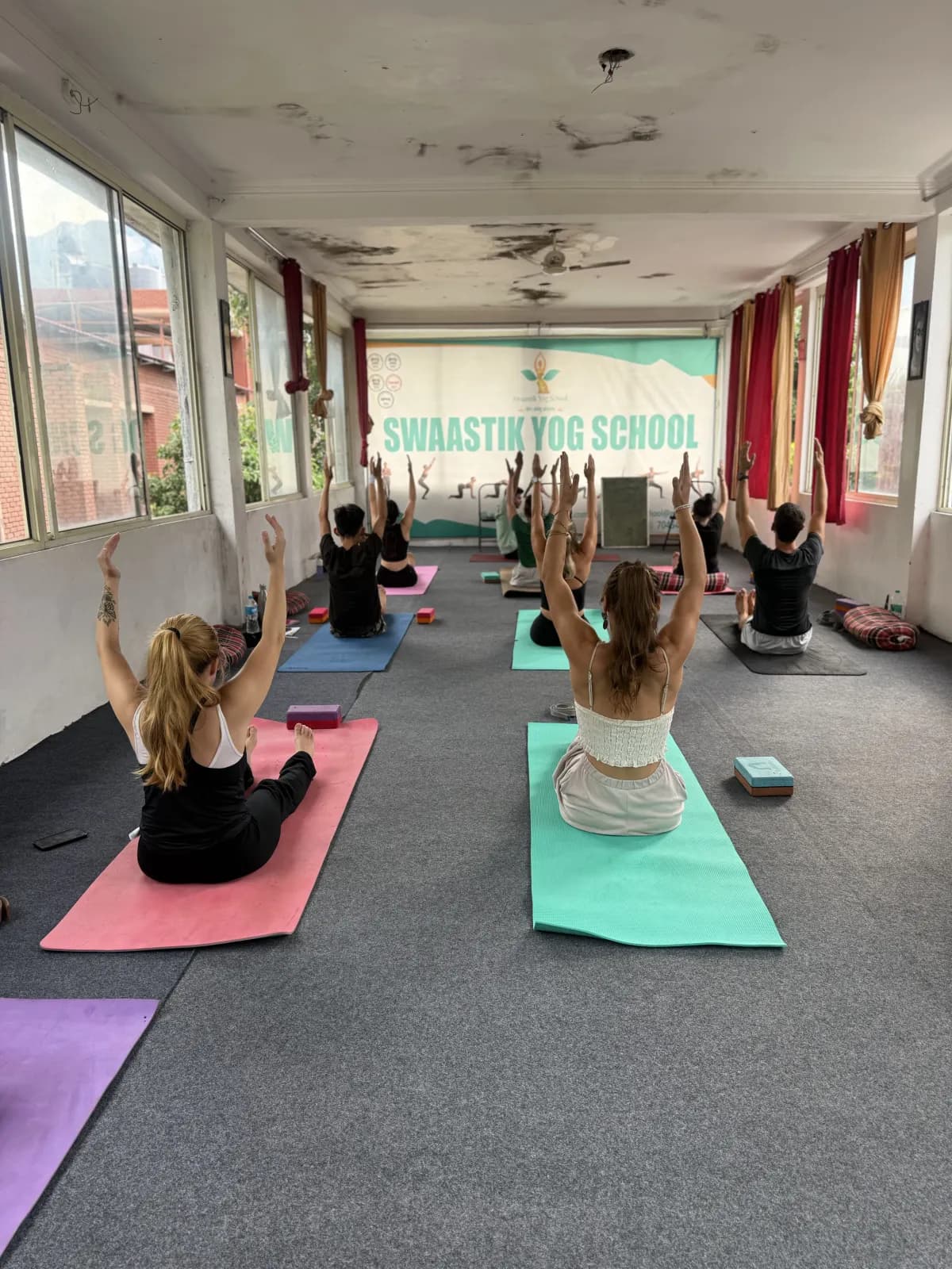 Small yoga class practising in the bright Swaastik Yog School hall