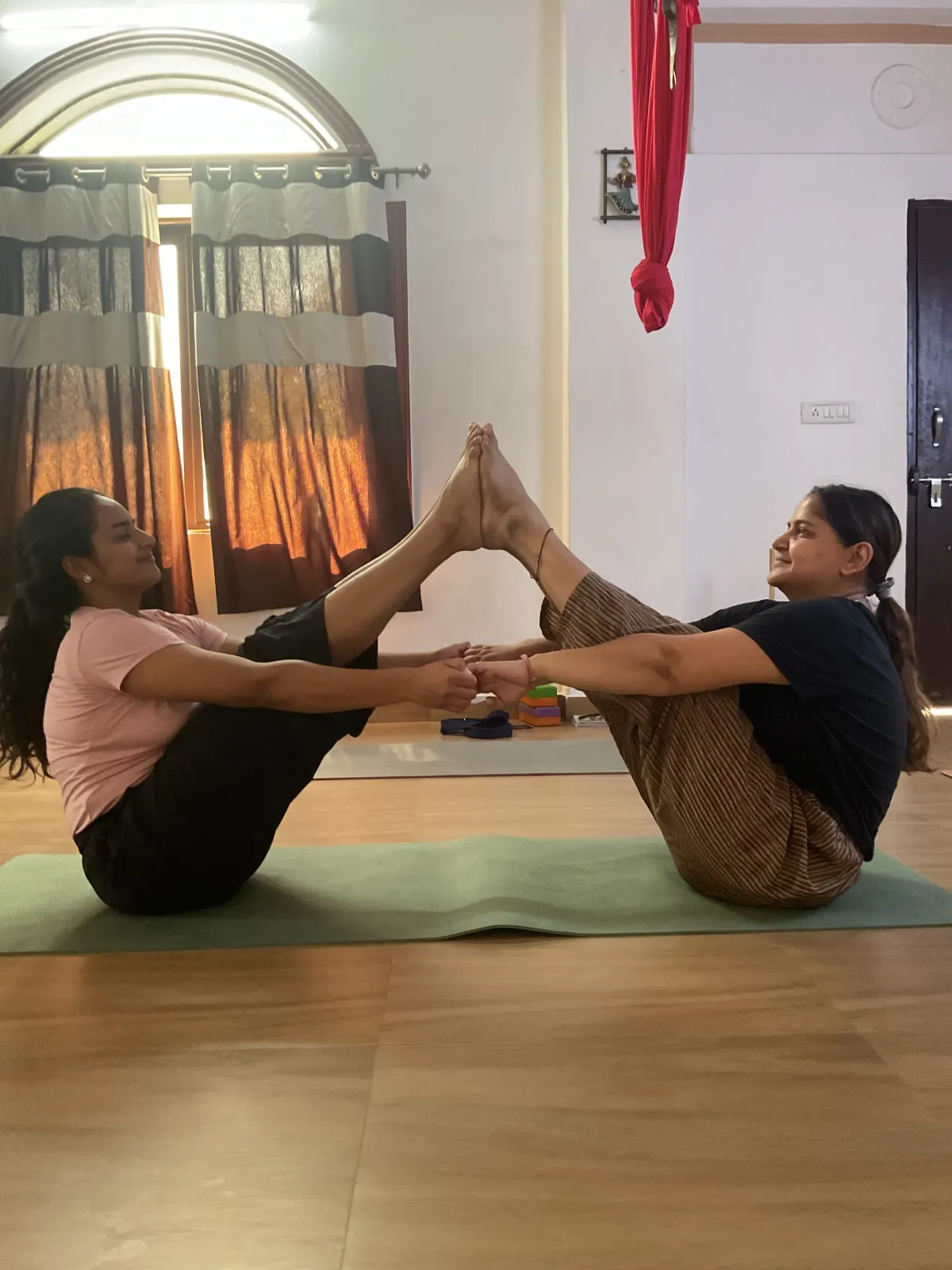 Two students in a partner yoga stretch during teacher training